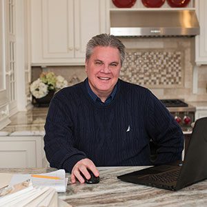 A man sitting at the kitchen counter with his laptop.