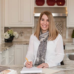 A woman sitting at the table writing in her notebook.