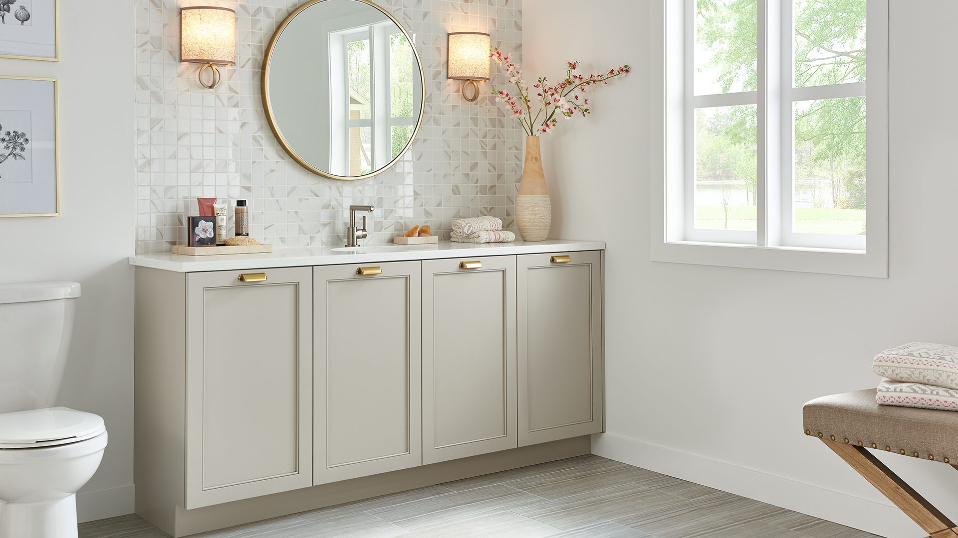A bathroom with white cabinets and a large mirror.