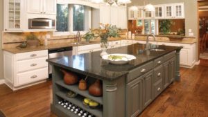 A kitchen with an island and granite counter tops.