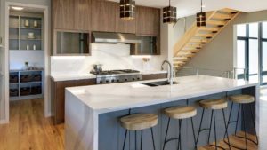 A kitchen with a sink and stools in it