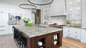 A kitchen with a large island and granite countertops.