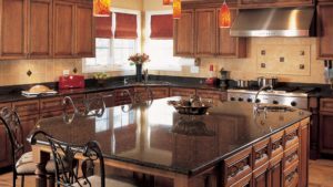 A large kitchen with granite counter tops and wooden cabinets.