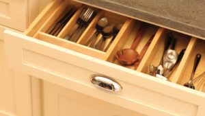 A drawer with many compartments and utensils in it