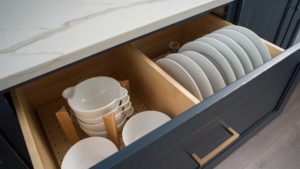 A drawer with many white dishes in it