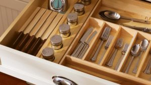 A drawer with many compartments and silverware.