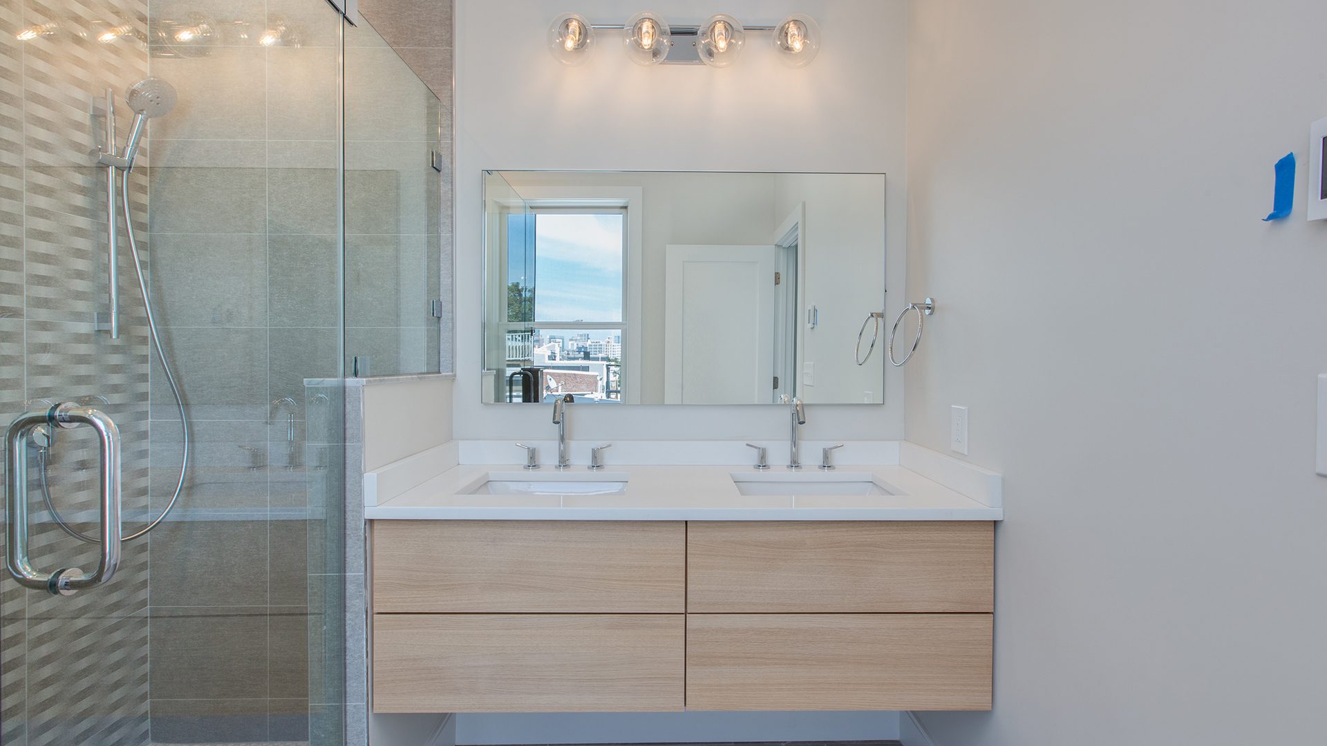 A bathroom with two sinks and a large mirror.