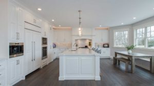 A large white kitchen with an island in the middle.