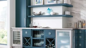 A blue and white kitchen with wine glasses on the counter