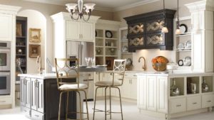 A kitchen with white cabinets and black island.