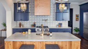A kitchen with blue cabinets and wooden island.