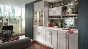 A kitchen with white cabinets and gray walls.