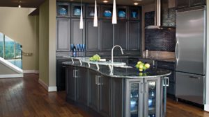 A kitchen with dark cabinets and a large island.