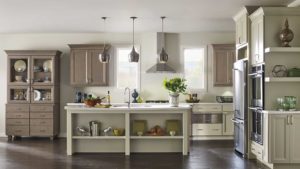 A kitchen with a large island and two hanging lights.