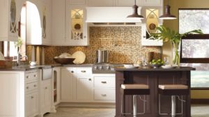 A kitchen with white cabinets and brown tile backsplash.