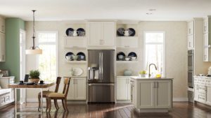 A kitchen with white cabinets and black plates on the wall.