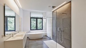 A bathroom with a large glass shower and a white tub.