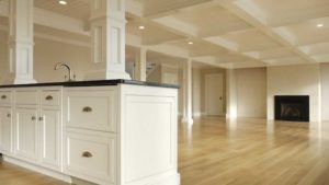 A kitchen with hard wood floors and white cabinets.