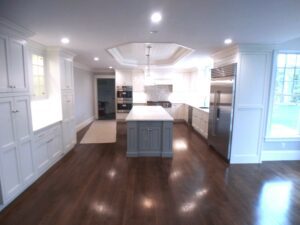 A large kitchen with white cabinets and wood floors.