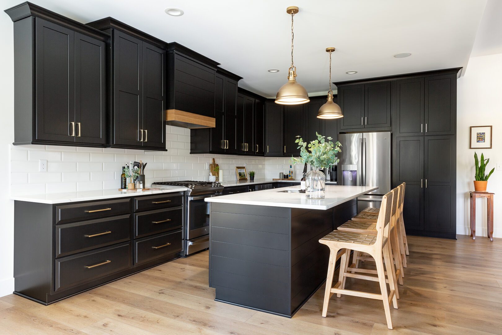 A kitchen with black cabinets and white counter tops.