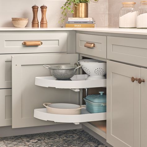 A kitchen with white cabinets and drawers, and a corner cabinet.