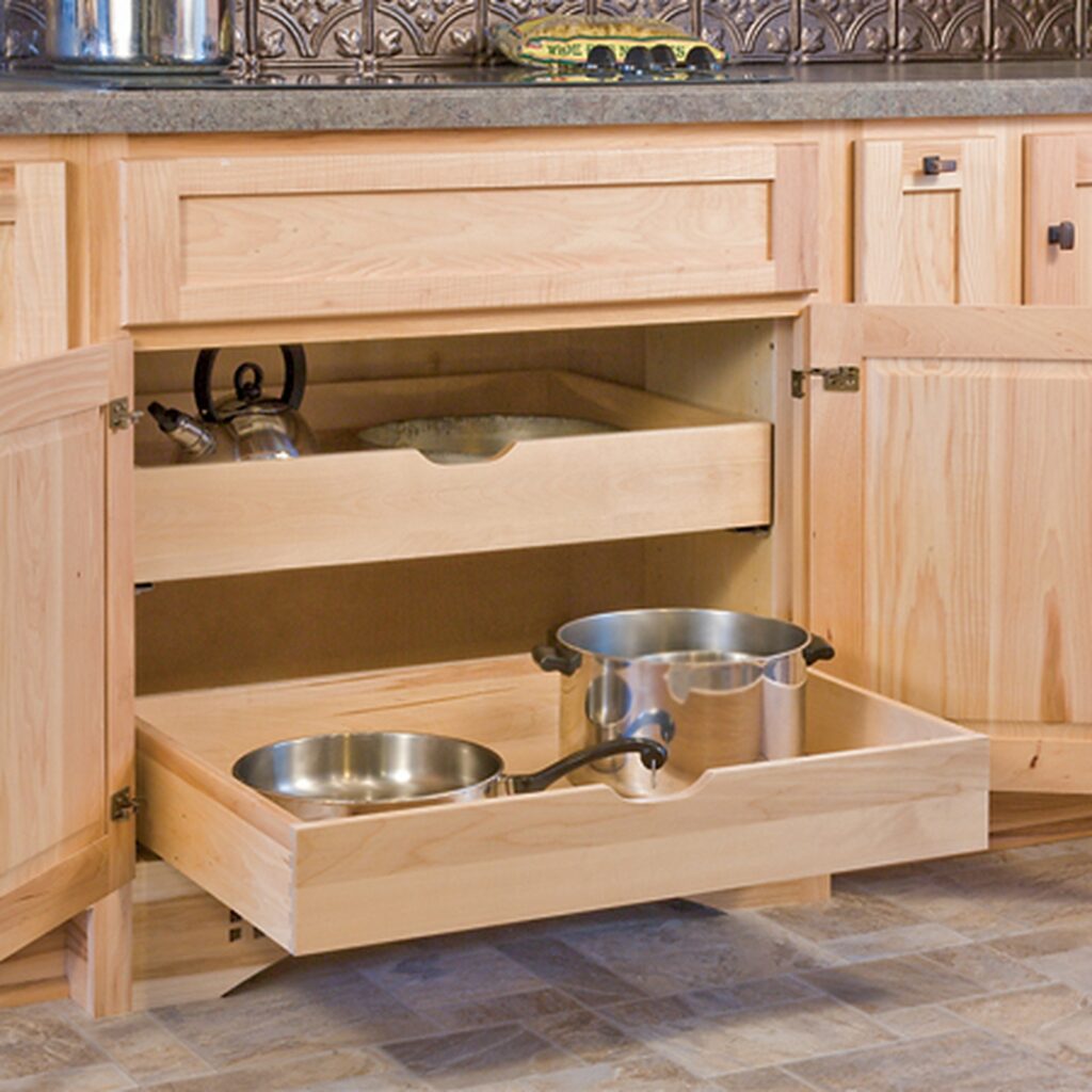 A kitchen with wooden cabinets and drawers that have bowls on them.