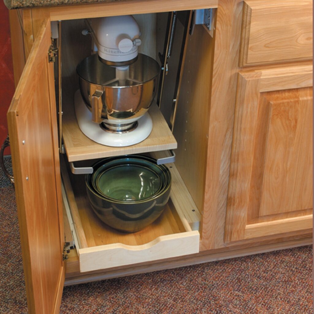 A kitchen cabinet with pull out shelves and a mixer.