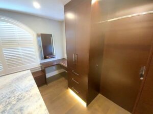 A large wooden cabinet in the middle of a bathroom.