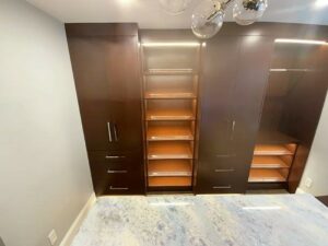 A room with some brown cabinets and shelves