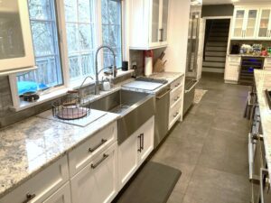 A kitchen with white cabinets and stainless steel sink.