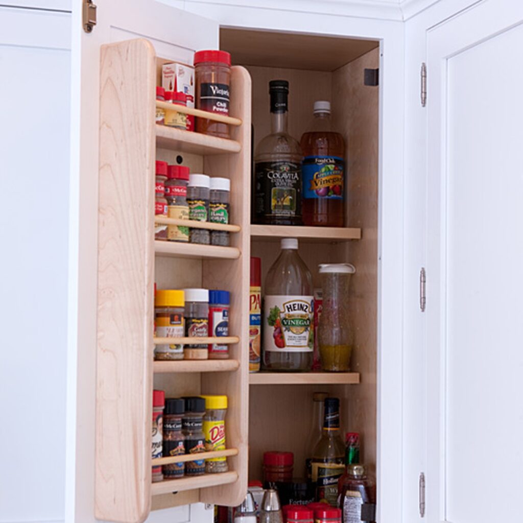 A tall cabinet with spices and condiments in it.