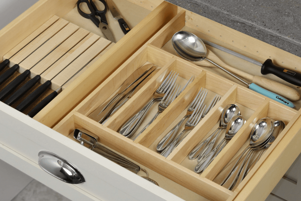 A drawer with many silverware and utensils in it