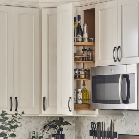 A kitchen with white cabinets and stainless steel microwave.