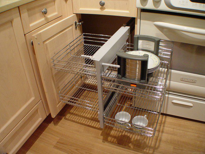 A kitchen with a pull out shelf and two drawers.