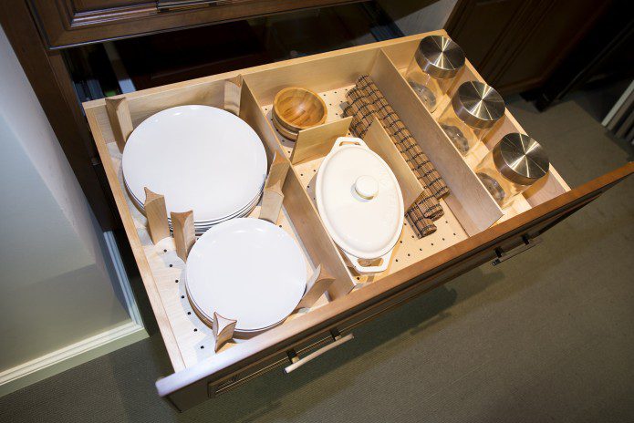 A drawer with dishes and cups in it