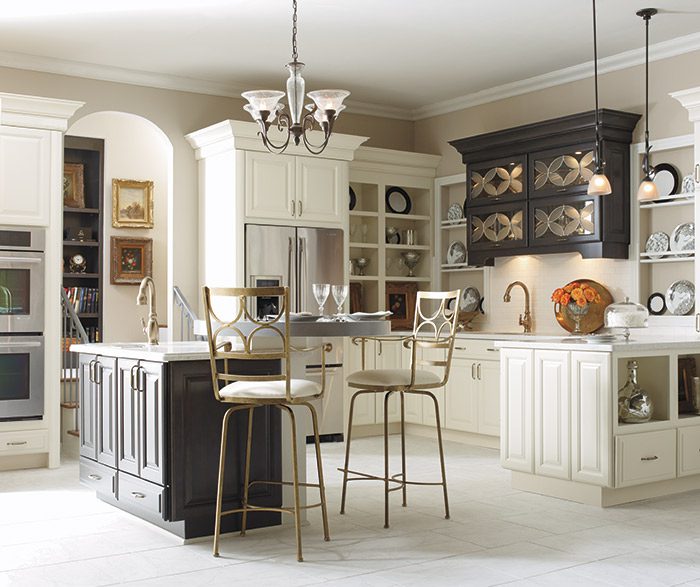 A kitchen with white cabinets and black island.