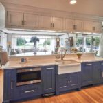 A kitchen with blue cabinets and white counters