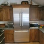 A stainless steel refrigerator in the middle of a kitchen.
