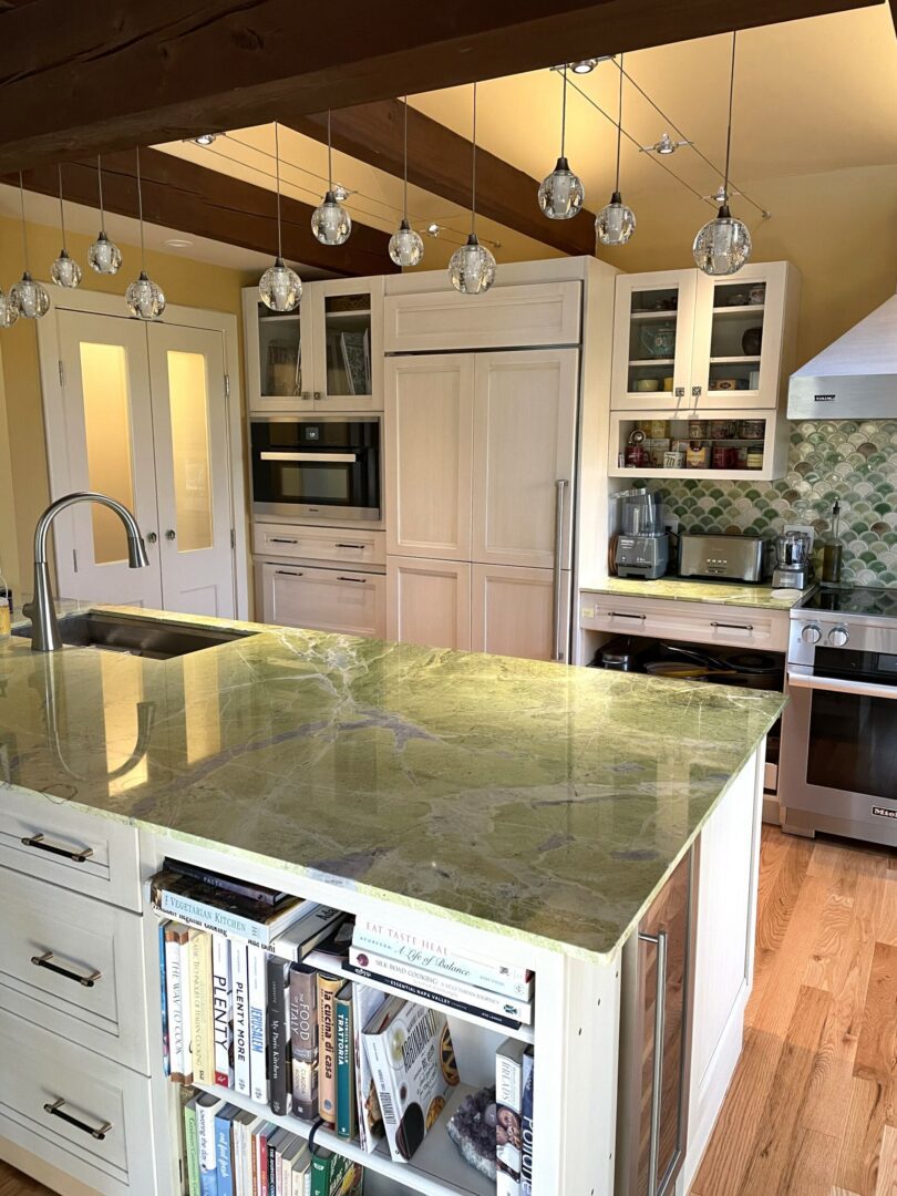 A kitchen with a large island and white cabinets.