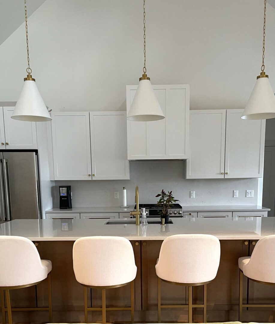A kitchen with white cabinets and chairs in it