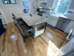 A kitchen with wooden floors and granite counter tops.