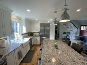 A kitchen with white cabinets and granite counter tops.