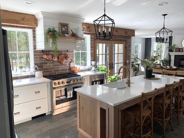 A kitchen with a large island and white cabinets.