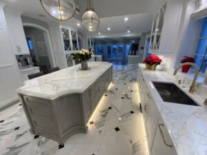 A kitchen with marble floors and white cabinets.