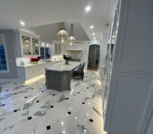 A kitchen with marble floors and white cabinets.
