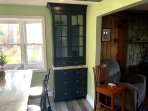 A black cabinet in the corner of a room.