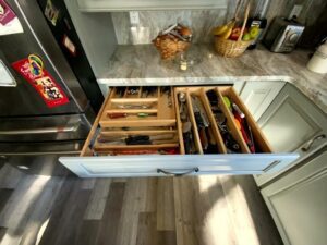A kitchen with an open drawer and many compartments.