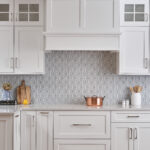 A kitchen with white cabinets and a tile backsplash.