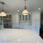 A kitchen with two lights and white cabinets