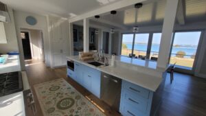 Modern kitchen interior with a sea view through large windows.